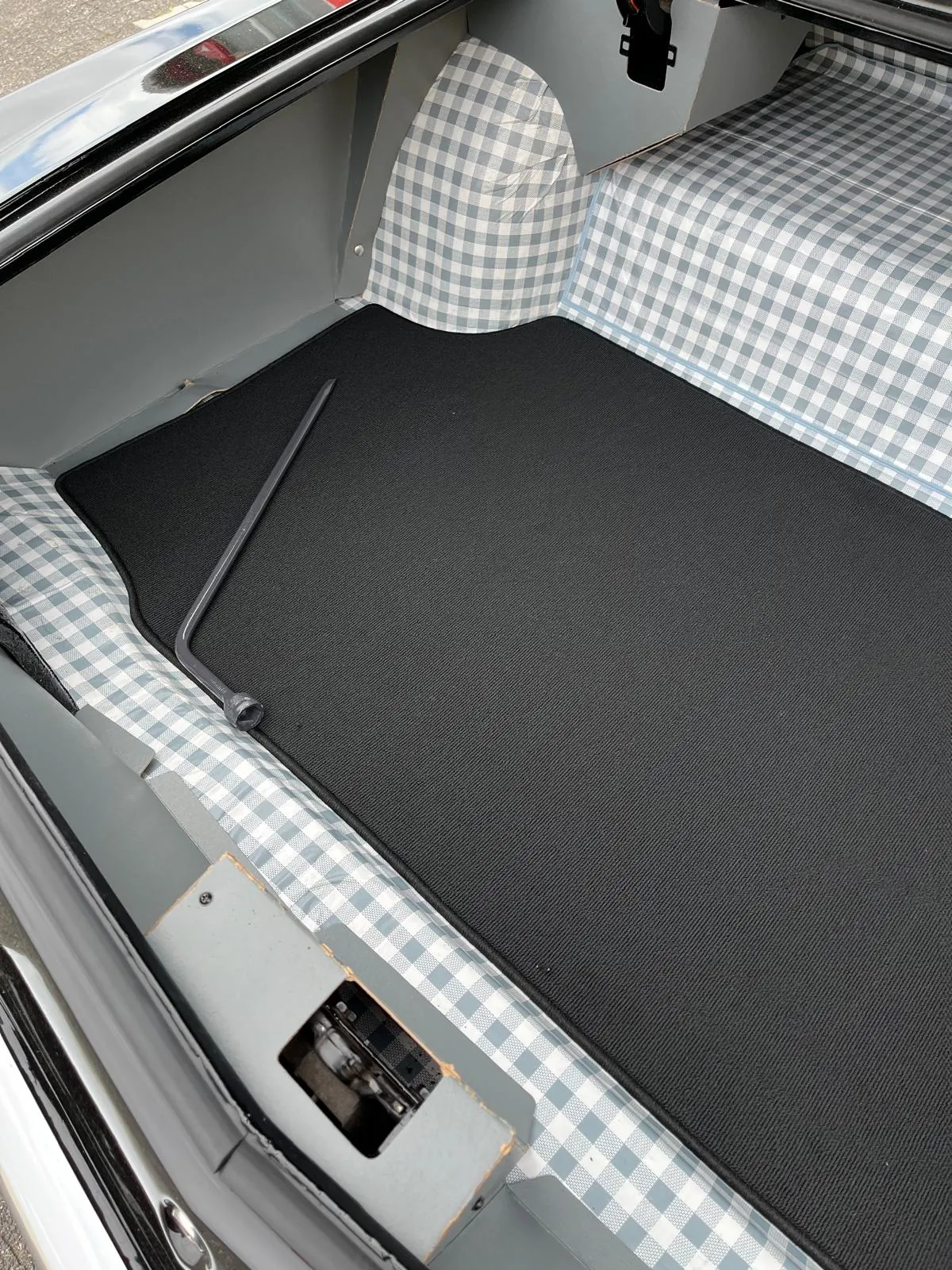 Blick in den Kofferaum eines Buick Riviera 1964, verkleidet mit einer schwarzen Kofferraummmatte.