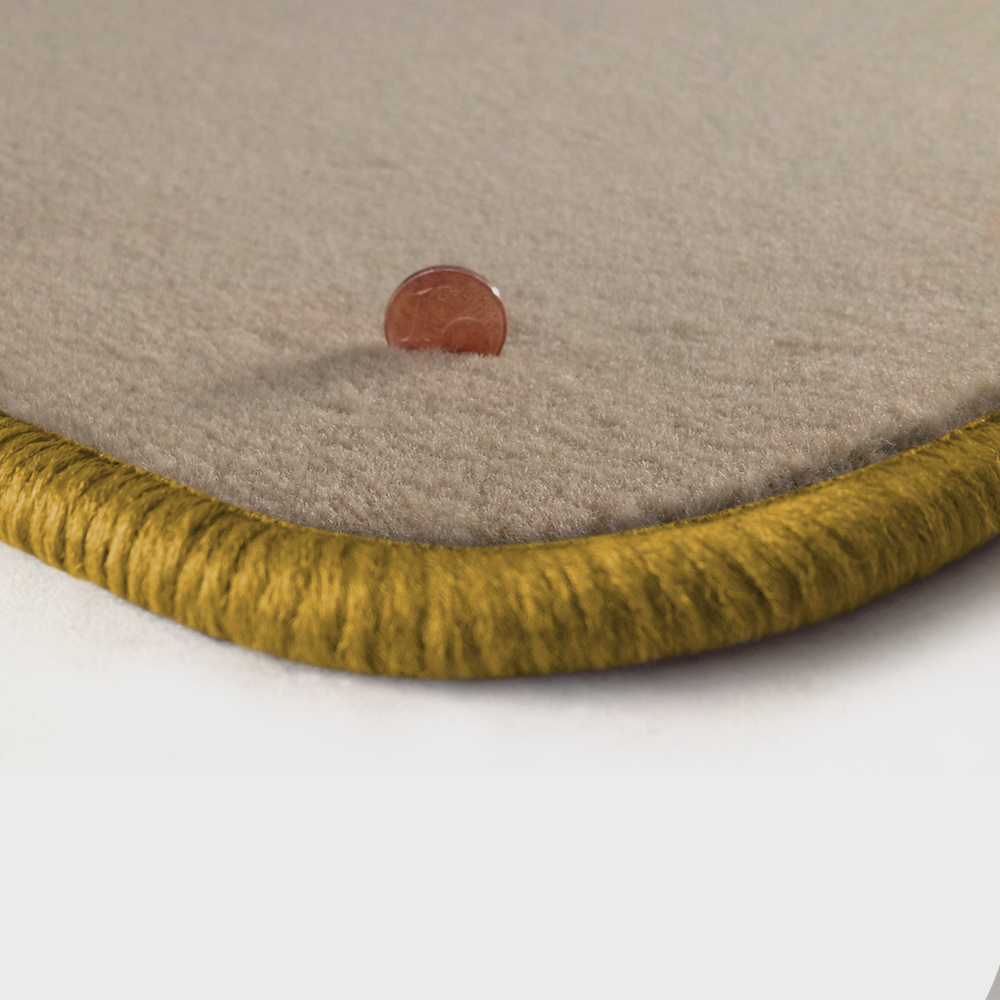 Eine Ecke als Beispiel einer Fussmatte Velours beige mit Rand in gold.