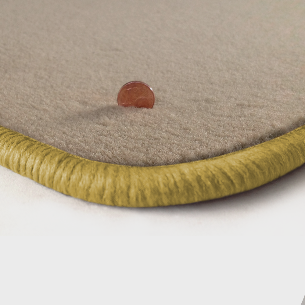 Eine Ecke als Beispiel einer Fussmatte Velours beige mit Rand in safran.