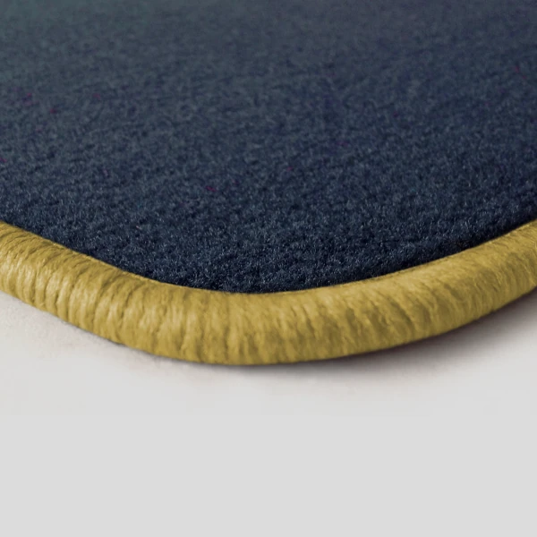 Eine Ecke als Beispiel einer Fussmatte Velours dunkelblau mit Rand in safran.