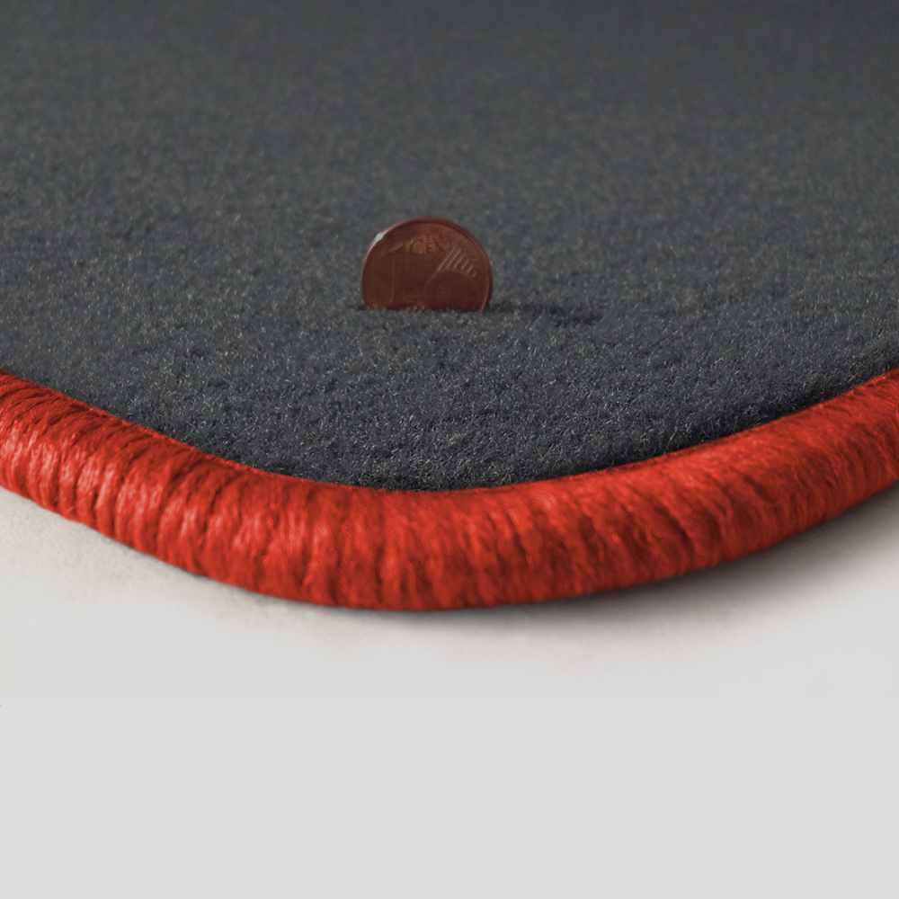 Eine Ecke als Beispiel einer Fussmatte Velours dunkelgrau mit Rand in orange.