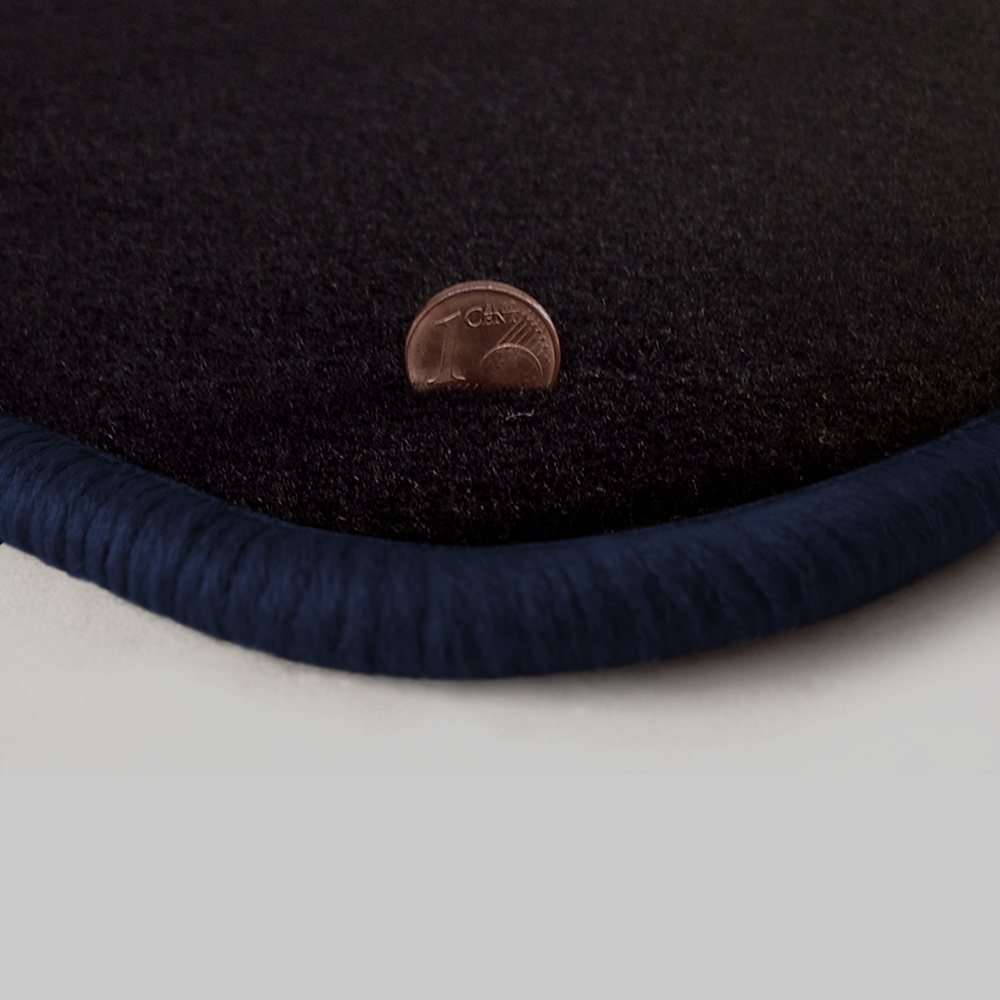 Eine Ecke als Beispiel einer Fussmatte Velours schwarz mit Rand in dunkelblau.