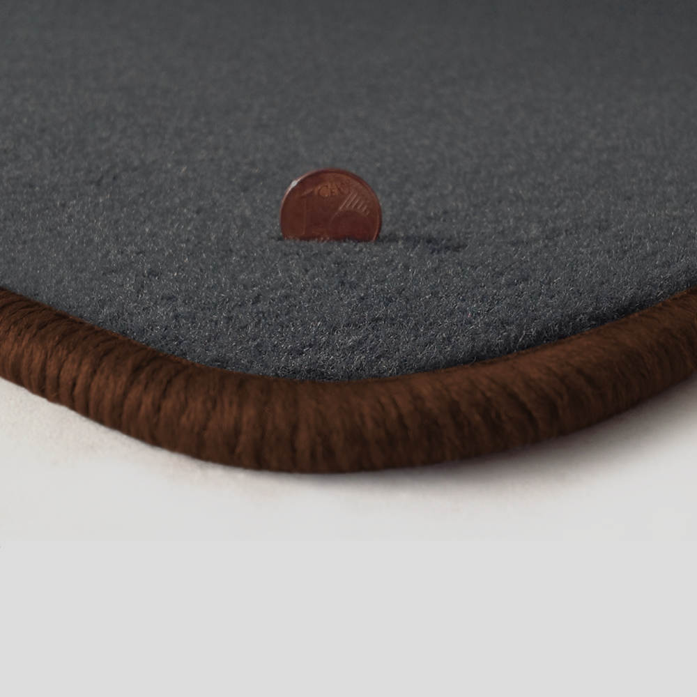 Eine Ecke als Beispiel einer Fussmatte Velours dunkelgrau mit Rand in braun.