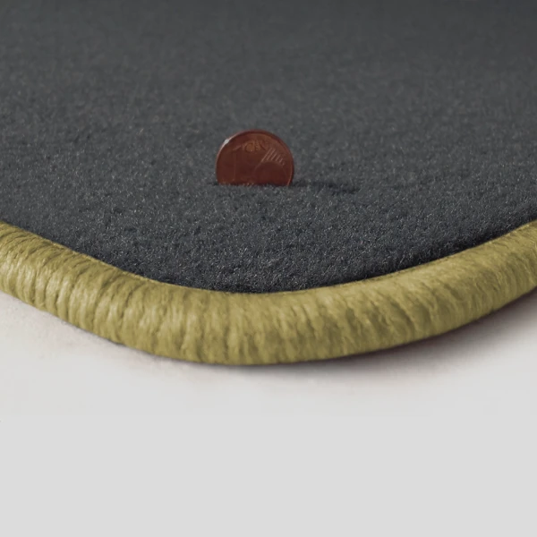 Eine Ecke als Beispiel einer Fussmatte Velours dunkelgrau mit Rand in mittelbeige.