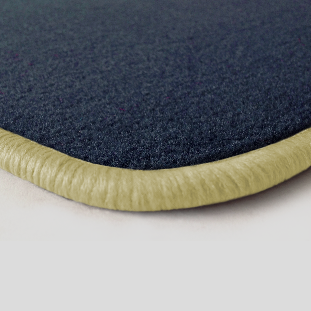 Eine Ecke als Beispiel einer Fussmatte Velours dunkelblau mit Rand in hellbeige.