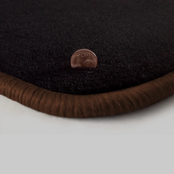Eine Ecke als Beispiel einer Fussmatte Velours schwarz mit Rand in braun.