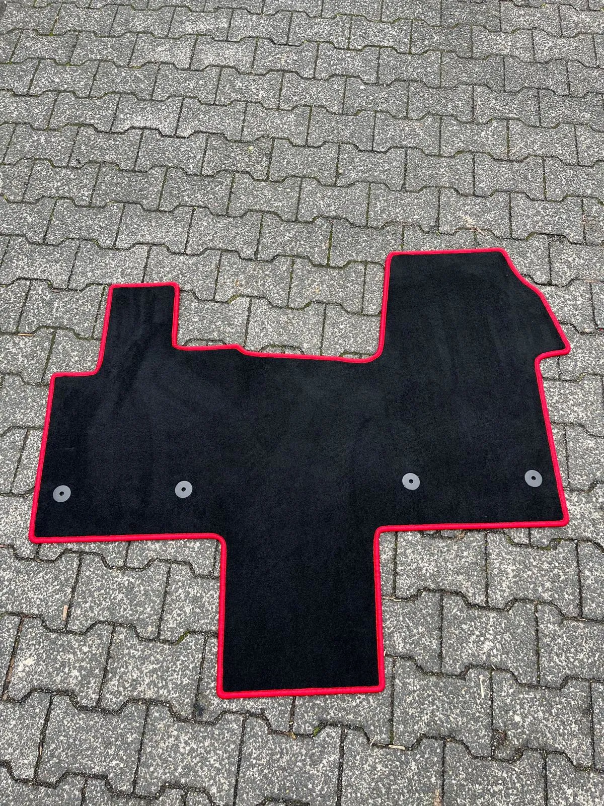 Blick auf eine schwarze, perfekt für die Fahrerkabine zugeschnittene Fußbodenmatte eines VW T7 New Multivan 5