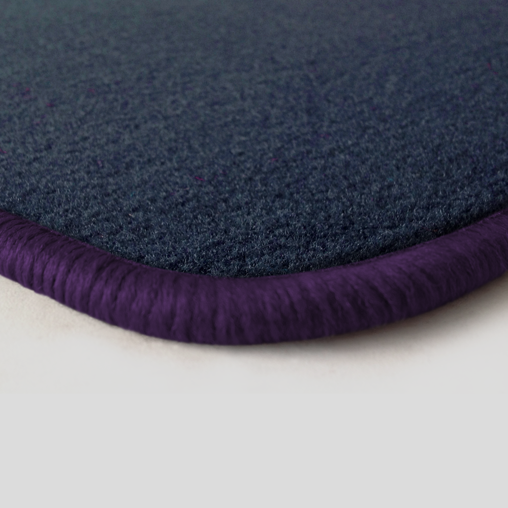 Eine Ecke als Beispiel einer Fussmatte Velours dunkelblau mit Rand in violett.