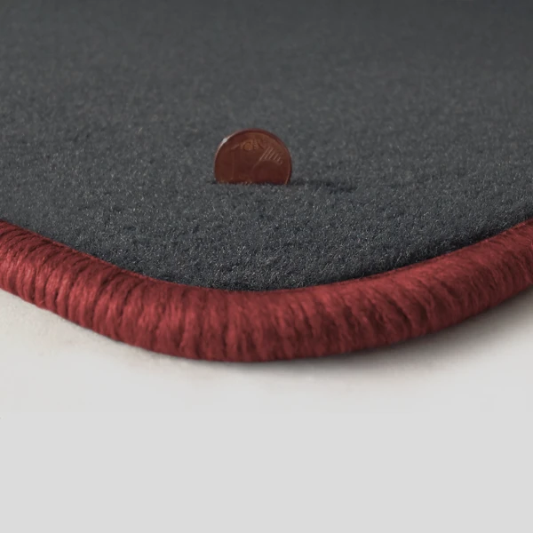 Eine Ecke als Beispiel einer Fussmatte Velours dunkelgrau mit Rand in rose.