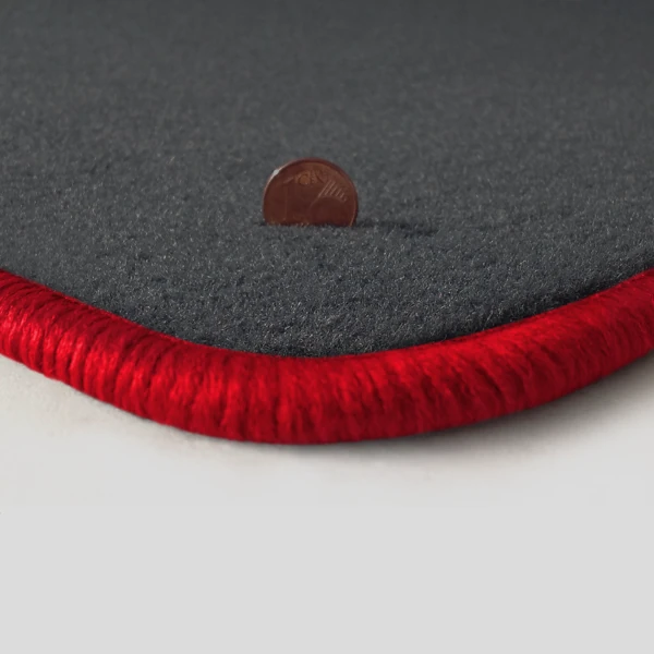 Eine Ecke als Beispiel einer Fussmatte Velours dunkelgrau mit Rand in rot.