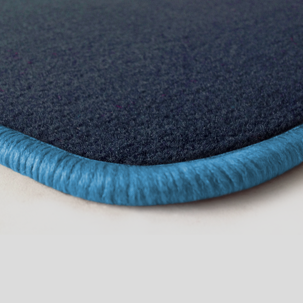 Eine Ecke als Beispiel einer Fussmatte Velours dunkelblau mit Rand in hellblau.