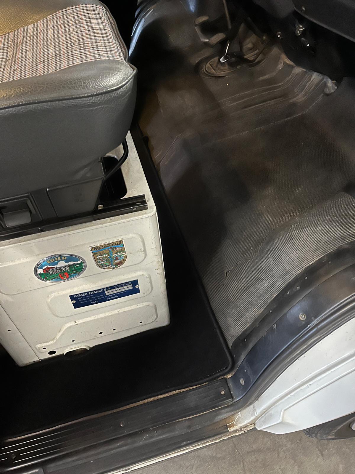 Blick beim Einsteigen auf der Beifahrerseite auf den neuen Teppich im Fußraum der Fahrerkabine