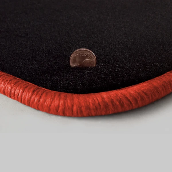 Eine Ecke als Beispiel einer Fussmatte Velours schwarz mit Rand in orange.