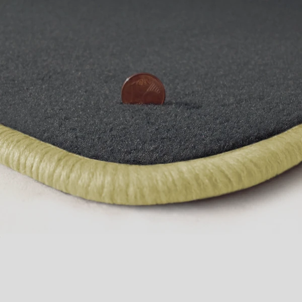 Eine Ecke als Beispiel einer Fussmatte Velours dunkelgrau mit Rand in hellbeige.