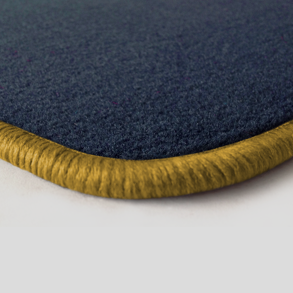 Eine Ecke als Beispiel einer Fussmatte Velours dunkelblau mit Rand in gold.