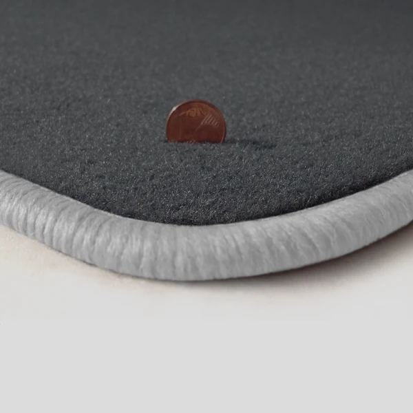 Eine Ecke als Beispiel einer Fussmatte Velours dunkelgrau mit Rand in weiss.