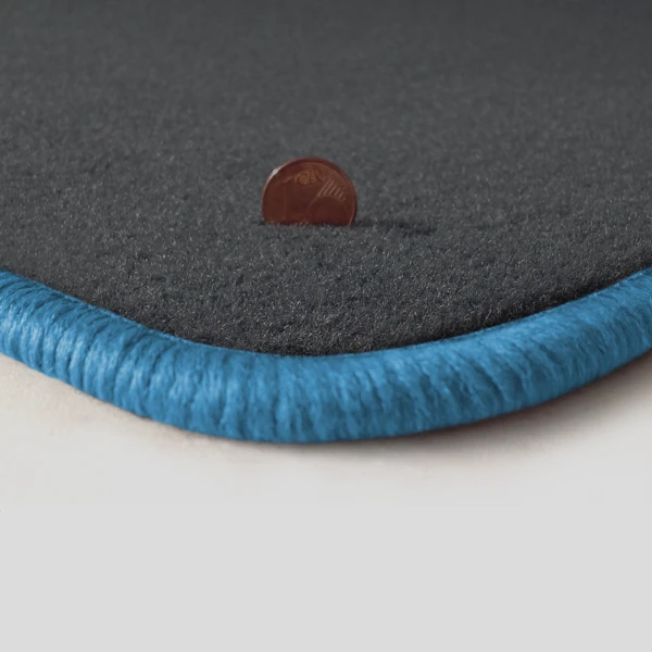 Eine Ecke als Beispiel einer Fussmatte Velours dunkelgrau mit Rand in hellblau.