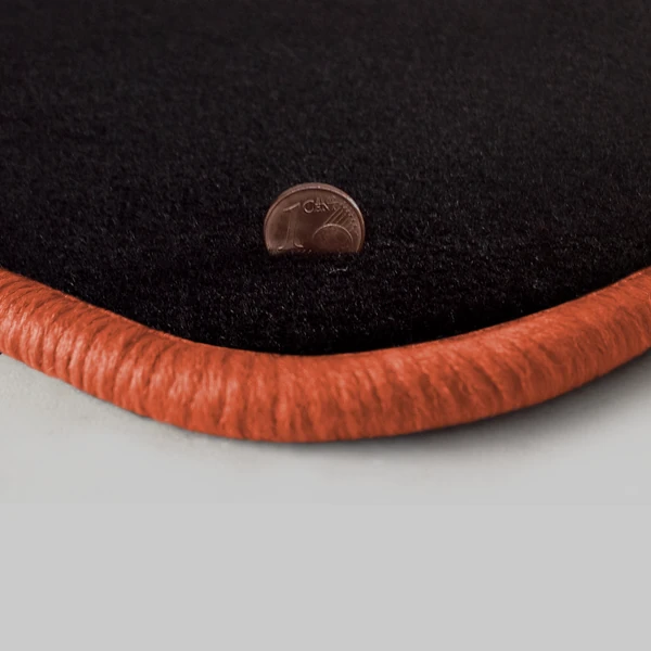 Eine Ecke als Beispiel einer Fussmatte Velours schwarz mit Rand in lachs.