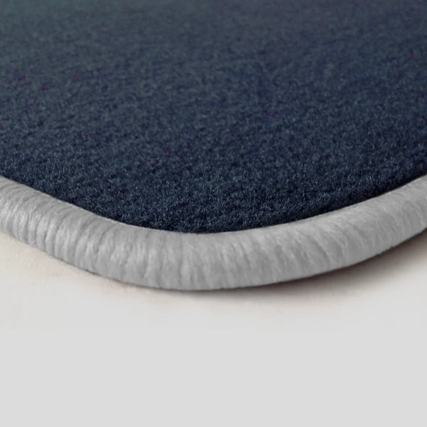 Eine Ecke als Beispiel einer Fussmatte Velours dunkelblau mit Rand in weiss.