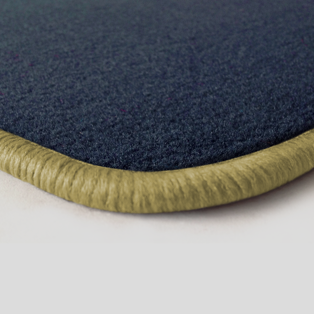 Eine Ecke als Beispiel einer Fussmatte Velours dunkelblau mit Rand in mittelbeige.