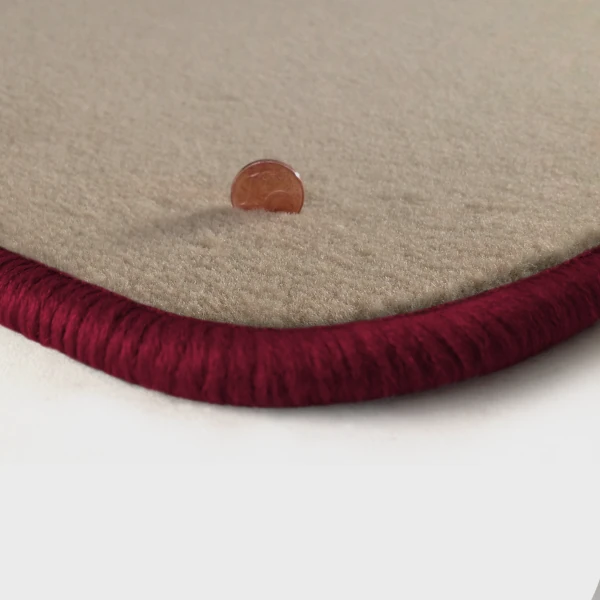 Eine Ecke als Beispiel einer Fussmatte Velours beige mit Rand in bordeaux.