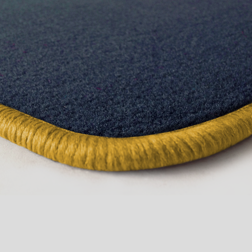 Eine Ecke als Beispiel einer Fussmatte Velours dunkelblau mit Rand in gelb.