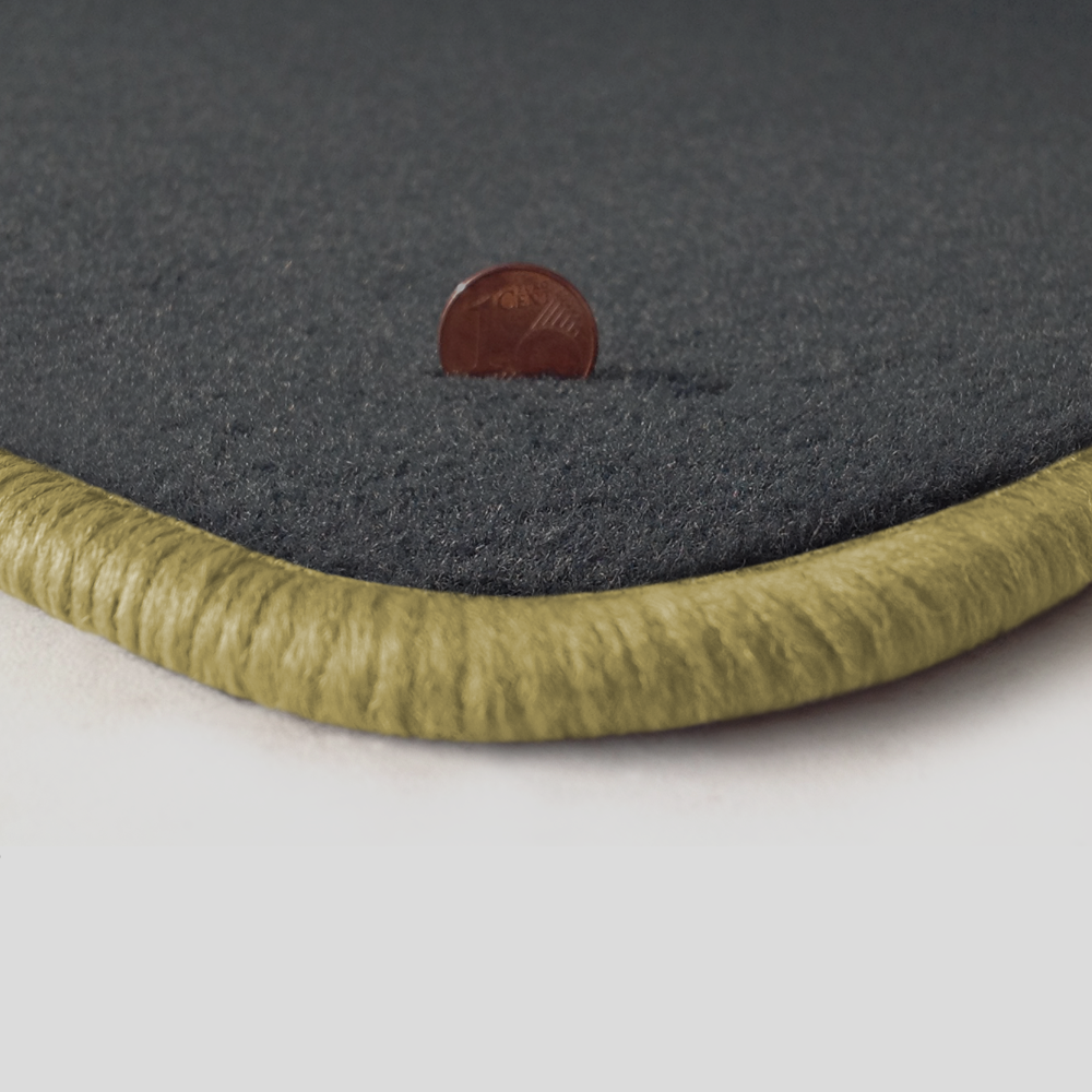 Eine Ecke als Beispiel einer Fussmatte Velours dunkelgrau mit Rand in mittelbeige.