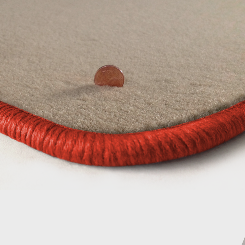 Eine Ecke als Beispiel einer Fussmatte Velours beige mit Rand in orange.