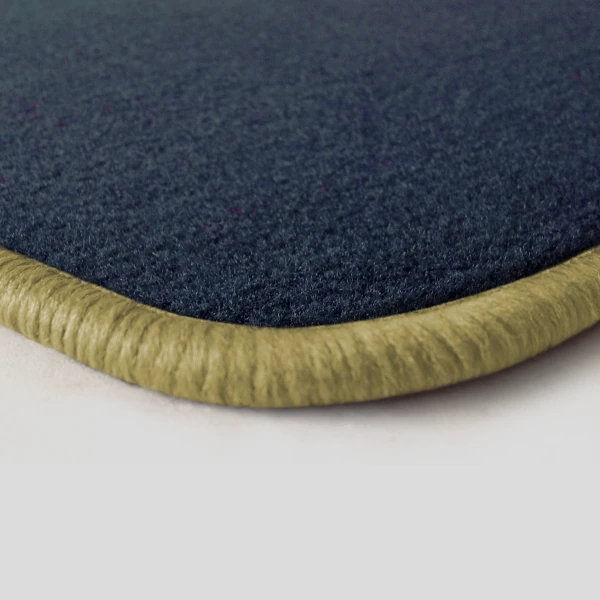Eine Ecke als Beispiel einer Fussmatte Velours dunkelblau mit Rand in mittelbeige.