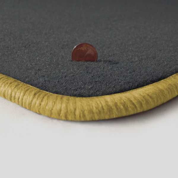 Eine Ecke als Beispiel einer Fussmatte Velours dunkelgrau mit Rand in safran.