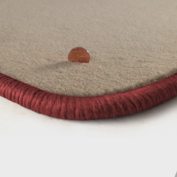 Eine Ecke als Beispiel einer Fussmatte Velours beige mit Rand in rose.