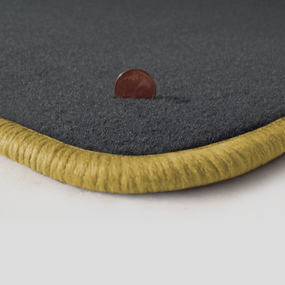 Eine Ecke als Beispiel einer Fussmatte Velours dunkelgrau mit Rand in safran.