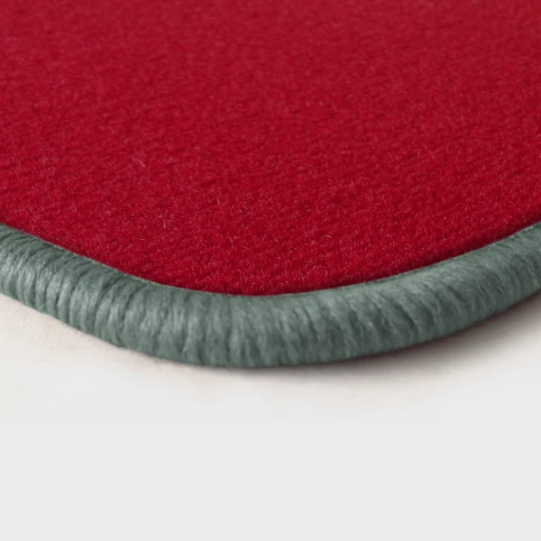Eine Ecke als Beispiel einer Fussmatte Velours rot mit Rand in silbergrau.