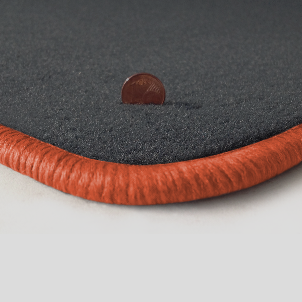 Eine Ecke als Beispiel einer Fussmatte Velours dunkelgrau mit Rand in lachs.