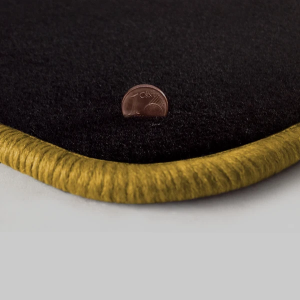 Eine Ecke als Beispiel einer Fussmatte Velours schwarz mit Rand in gold.