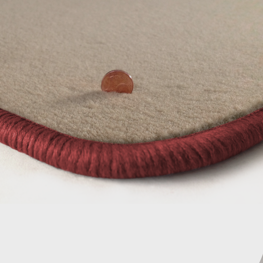 Eine Ecke als Beispiel einer Fussmatte Velours beige mit Rand in rose.