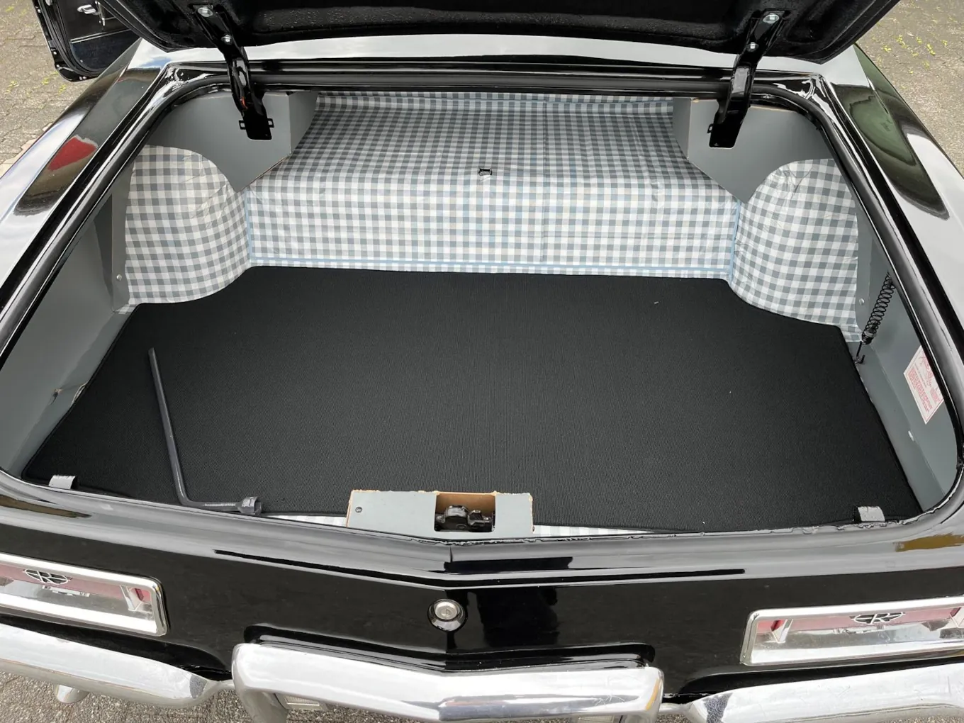 Blick in den Kofferaum eines Buick Riviera 1964, verkleidet mit einer schwarzen Kofferraummmatte.