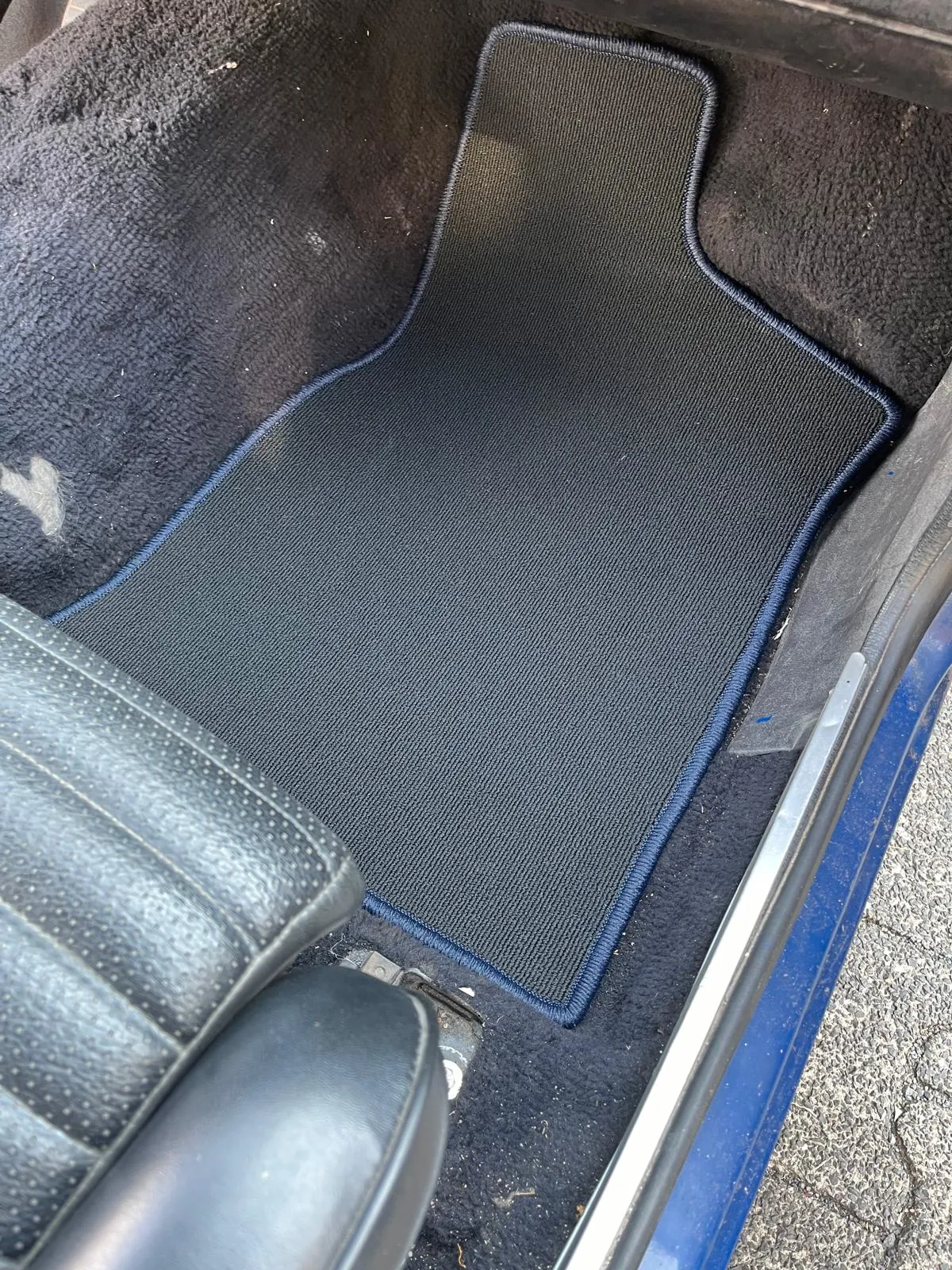 Blick in den Beifahrerfußraum eines Ford Escort mit einer eingepassten Fußmatte