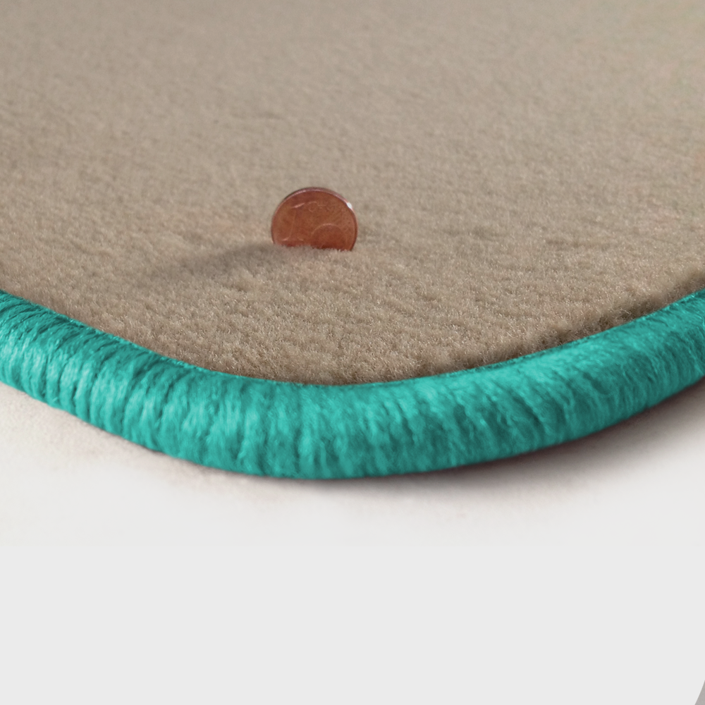 Eine Ecke als Beispiel einer Fussmatte Velours beige mit Rand in mint.