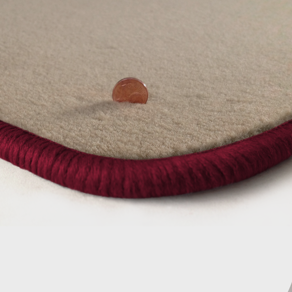 Eine Ecke als Beispiel einer Fussmatte Velours beige mit Rand in bordeaux.