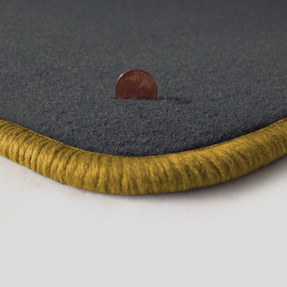 Eine Ecke als Beispiel einer Fussmatte Velours dunkelgrau mit Rand in gold.