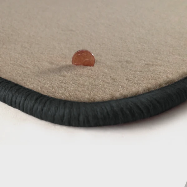Eine Ecke als Beispiel einer Fussmatte Velours beige mit Rand in dunkelgrau.