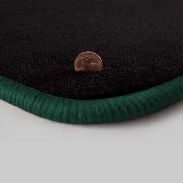 Eine Ecke als Beispiel einer Fussmatte Velours schwarz mit Rand in dunkelgruen.